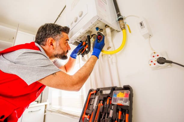 Middle-aged, bearded  man repair gas boiler with wrenches, Gas Heating Boiler Service At Home
